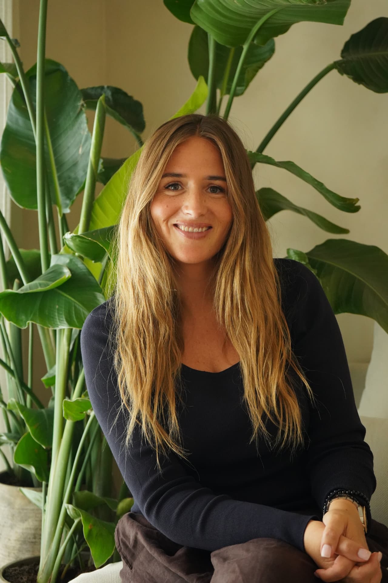 Cammilla Poulus sidder foran store grønne planter